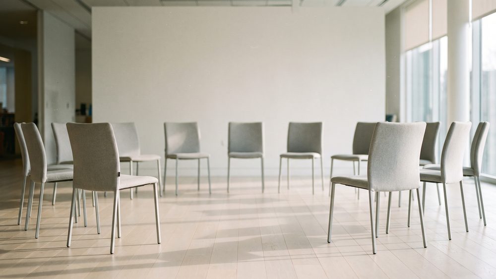 A half circle of chairs in a bright programme room, set out before a class.