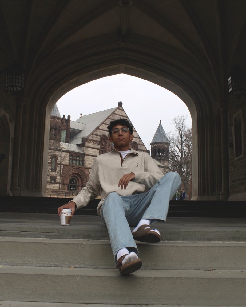 The founder of sparkk on the steps of a university archway.